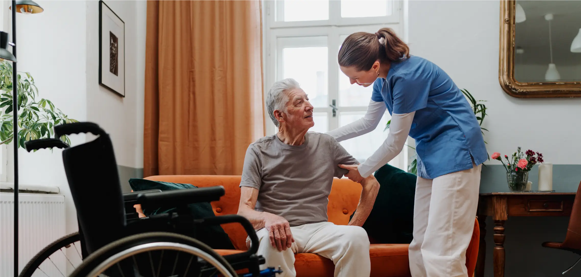 Caregiver helping an older adult with mobility and safe movement at home
