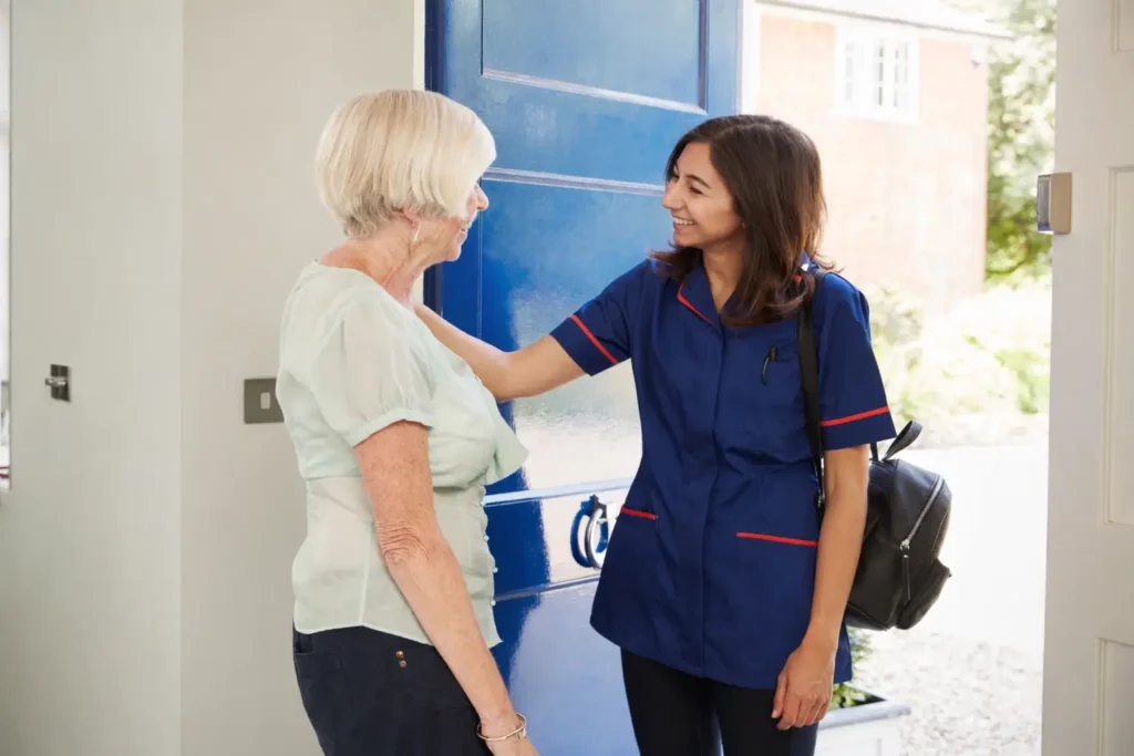 Nurse greeting elderly woman at front door for home care visit in Sussex and Surrey