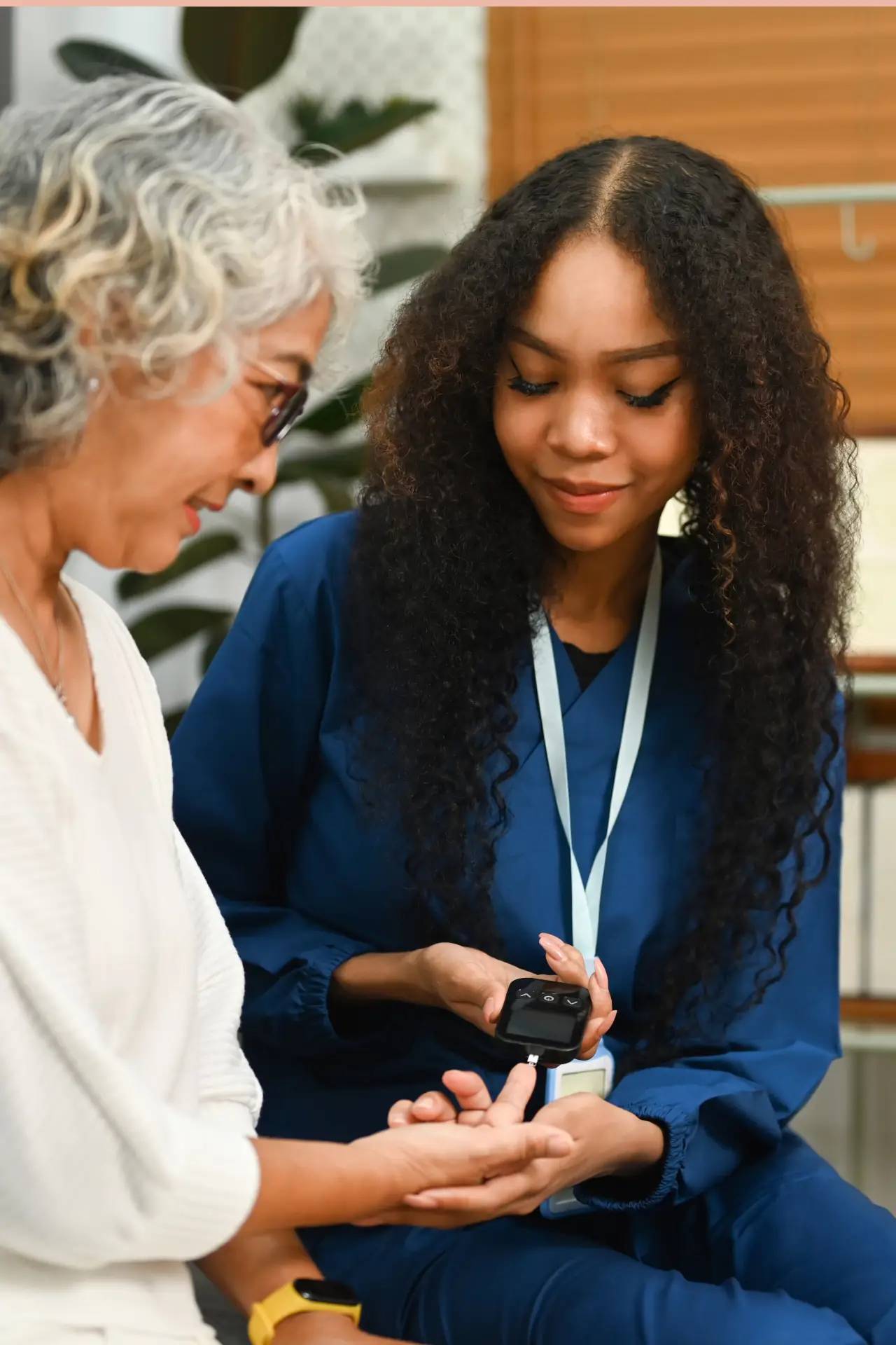 Nurse assisting elderly woman with blood glucose monitoring at home in Sussex and Surrey