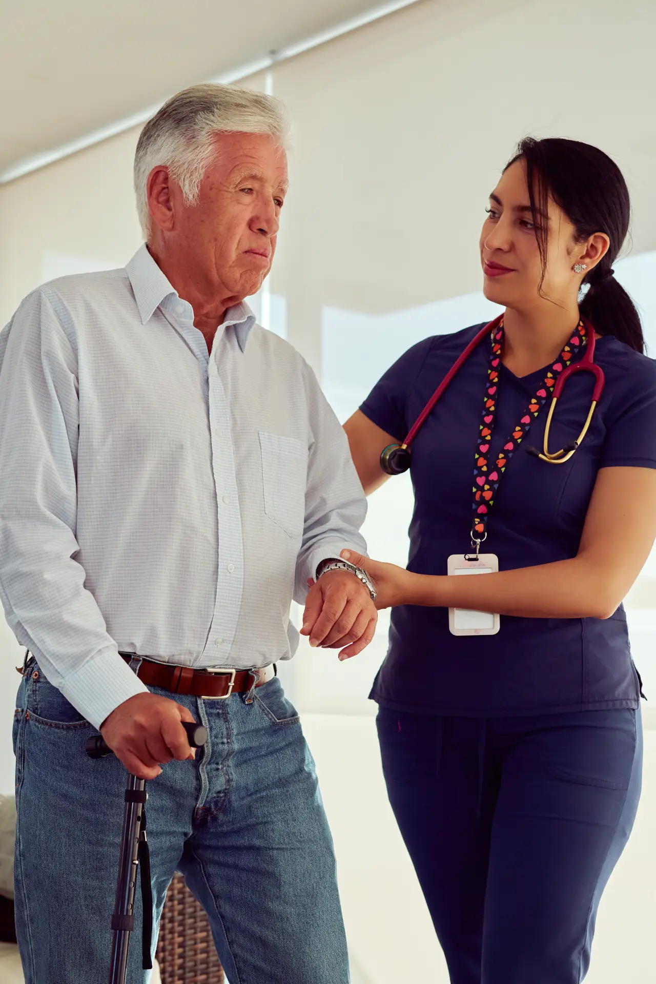 Nurse assisting elderly man with walking support and mobility at home in Sussex and Surrey