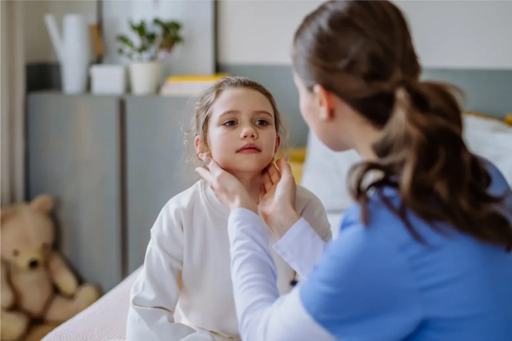 Care professional gently assessing a child’s health in a home setting