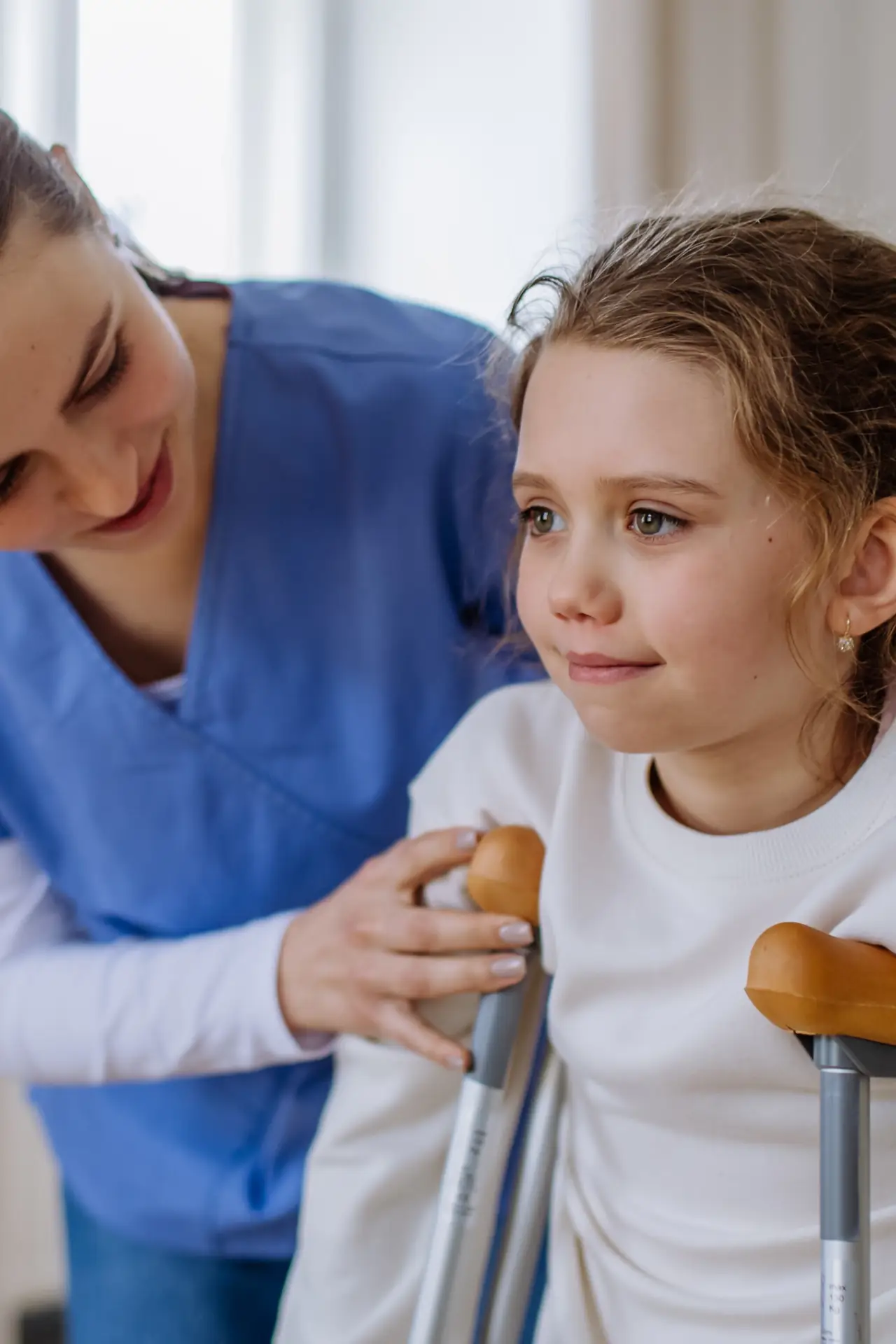 Care professional supporting a child with mobility and walking aids