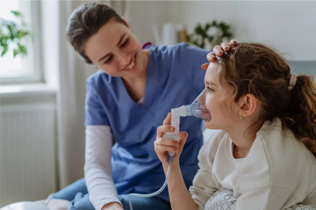Nurse supporting a child with respiratory treatment using a nebuliser