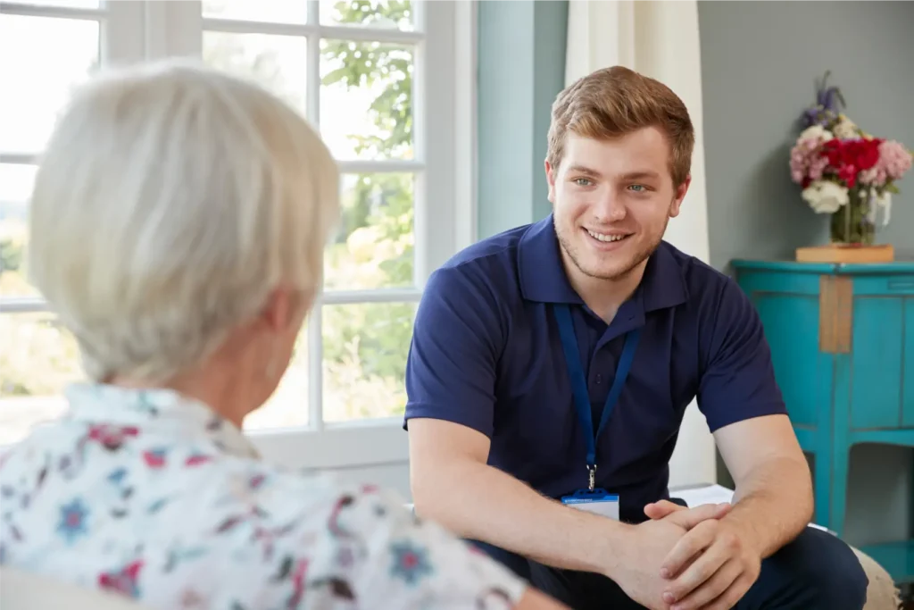Carer talking with elderly woman and providing companionship at home in Sussex and Surrey